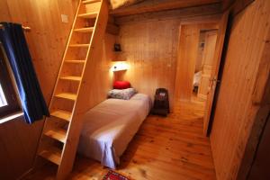Habitación pequeña con cama y escalera en Chalet Marion, en Montriond