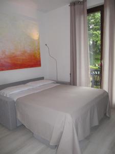 ein weißes Bett in einem Zimmer mit Fenster in der Unterkunft Sole di Lazise in Lazise + 13 Fotos
