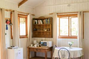 a small kitchen with a table and a microwave at Pear Tree Cottage in Stormsrivier