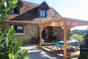 a wooden pavilion with a table in front of a house at B&B Le Relais de Chantecor in La Coquille