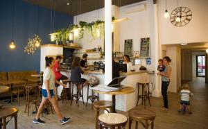 a group of people standing around a bar in a restaurant at Georges Hostel & Café in Sète