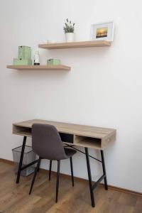 a wooden desk with a chair in front of a wall at Apartman Park in Daruvar