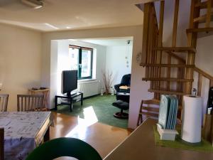 ein Wohnzimmer mit einer Treppe und einem TV in der Unterkunft Ferienwohnung am Eiskeller in Ankershagen