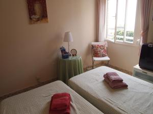 a bedroom with two beds and a window at Habitaciones frente a la playa in Málaga