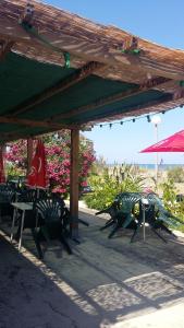 a group of tables and chairs under a pavilion at Camping Europa Beach in Castellare-di-Casinca