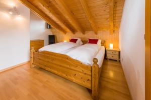 een slaapkamer met een groot houten bed in een kamer bij Spieliweida in Grächen