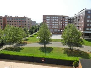 Blick auf einen Park mit Bäumen und Gebäuden in der Unterkunft Loft Gijón in Gijón