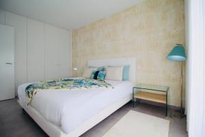 1 dormitorio con cama blanca y lámpara azul en Obidos House with private pool, en Bairro 28 fotos más