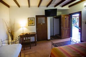 Un dormitorio con una cama, un escritorio y un televisor. en Hostería Posada del Sol, en Libertador General San Martín 53 fotos más