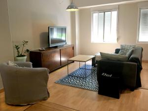 uma sala de estar com 2 cadeiras e uma televisão de ecrã plano em KOA Centric, comfy in Ruzafa em Valência