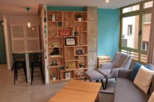 sala de estar con sofá y estante para libros en Piso con piscina y garaje en la Playa de Las Canteras, en Las Palmas de Gran Canaria