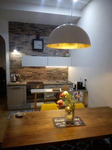 a kitchen with a wooden table with a vase of flowers at Covo Giulia in Genoa +7 photos