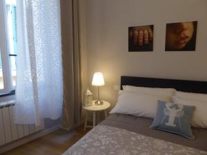a bedroom with a bed and a table with a lamp at Covo Giulia in Genoa