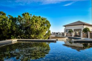 einem Wasserpool vor einem Gebäude in der Unterkunft Atlantica Aphrodite Hills Hotel in Kouklia