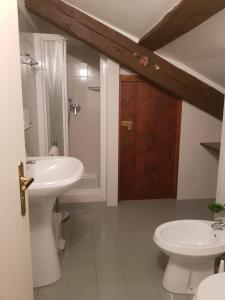 a white bathroom with a sink and a toilet at Casa Antica Mosaici in Trivignano Udinese