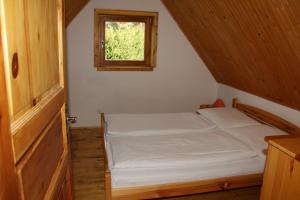 a small bed in a small room with a window at Chata Donovaly Buly 242/C in Donovaly