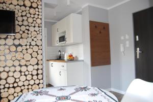 a room with a kitchen with a log wall at Pałac Tatrzański-Apartament 206 in Bukowina Tatrzańska