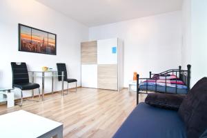 a living room with a bed and a table and chairs at Top Apartments in zentraler Lage in Cologne