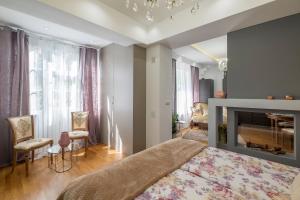 a bedroom with a large bed and a fireplace at Parliament Sofia - Top Center Luxury Apartment in Sofia