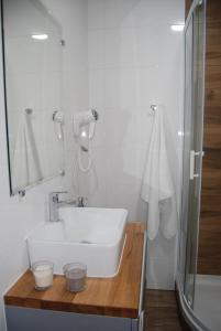 a white bathroom with a sink and a shower at Pałac Tatrzański-Apartament 206 in Bukowina Tatrzańska