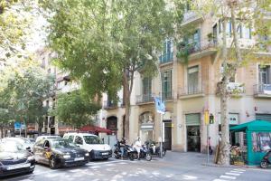 a street with cars and motorcycles parked in front of a building at Stay U-nique Apartments Plaça Universitat in Barcelona