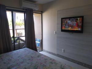 a bedroom with a bed and a tv on a wall at Eco Paradise ap 122 in Cumbuco