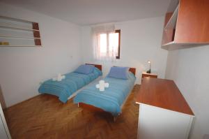two beds in a room with blue pillows at Apartments Daidzic in Njivice