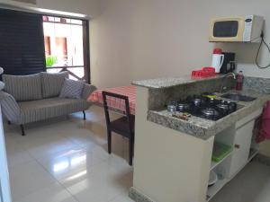 a kitchen with a counter with a stove and a couch at Eco Paradise ap 122 in Cumbuco