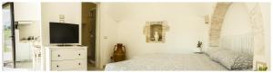 a bedroom with a bed and a flat screen tv at Marinelli Guest House in Cisternino