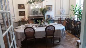 a dining room table with a white table cloth and chairs at Le Clôs Ste Anne in Eu