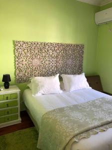 a bedroom with a large bed with a large headboard at Alojamento Local S. Bartolomeu in Trancoso