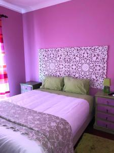 a purple bedroom with a bed with a purple wall at Alojamento Local S. Bartolomeu in Trancoso