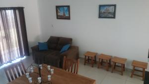 a living room with a couch and a table and chairs at Apartamentos Mirante de Escarpas in Capitólio