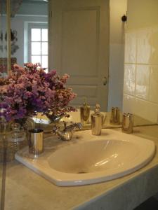 a bathroom sink with a vase of flowers on it at Le Clôs Ste Anne in Eu