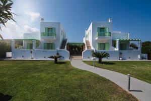 une maison blanche avec une cour gazonnée devant elle dans l'établissement Agalipa, à Skiros