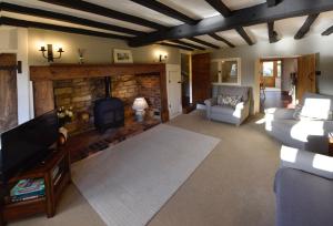 a living room with a fireplace and a couch at Bells Cottage in Alderton