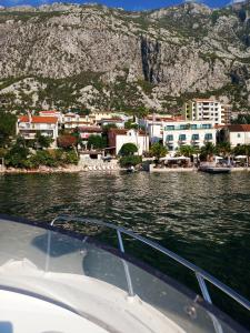 a boat in a body of water with a city at Villa Perla Del Mare in Kotor