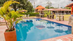 a pool at a resort with tables and chairs at Finca Hotel Cafetos in Montenegro +38 photos