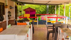 un restaurante con mesas y sillas y una zona de juegos en Finca Hotel Cafetos, en Montenegro