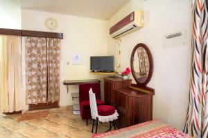 Habitación con cama, espejo y silla. en Sonnetta Residency, en Kochi