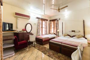a bedroom with two beds and a desk and a mirror at Sonnetta Residency in Cochin