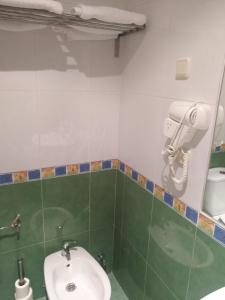 ein Badezimmer mit einem Waschbecken und einem Telefon an der Wand in der Unterkunft P Residencia PIVIDAL in Picaraña