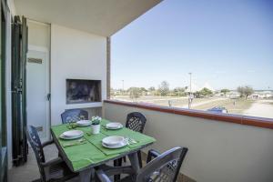 una mesa y sillas con una mesa verde y una ventana en Residence Smith Sul Mare en Lido degli Estensi