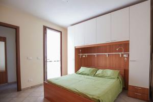 Schlafzimmer mit einem Bett mit einem Kopfteil aus Holz in der Unterkunft Residence Smith Sul Mare in Lido degli Estensi
