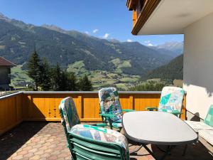 una mesa y sillas en un balcón con montañas en Sonnseitn Klaunz27, en Matrei in Osttirol