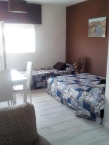 1 Schlafzimmer mit 2 Betten, einem Tisch und einem Stuhl in der Unterkunft Apartamento Buendia in Buendía