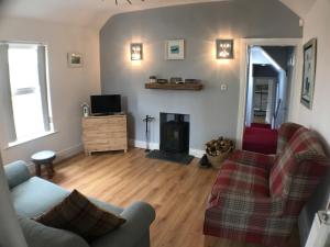 a living room with a couch and a fireplace at Ridge Cottage Portrush in Portrush