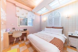 a bedroom with a bed and a desk and a chair at Story Inn City in Hualien City