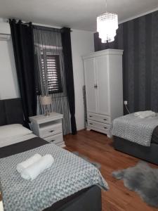 a bedroom with two beds and a chandelier at Apartman Sanja in Ploče