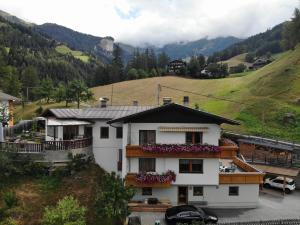 una casa blanca con flores en el balcón en Sonnseitn Klaunz27, en Matrei in Osttirol